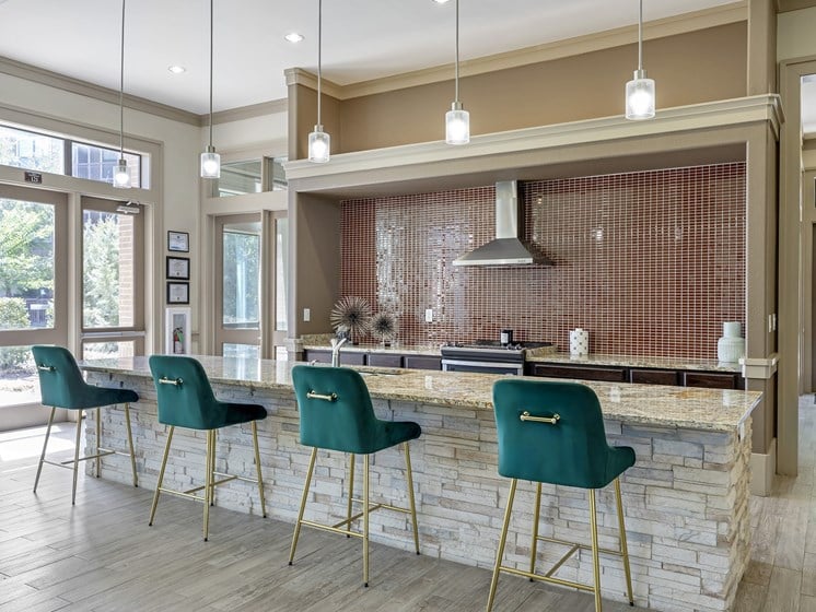 a kitchen with green bar stools in front of a stone counter top